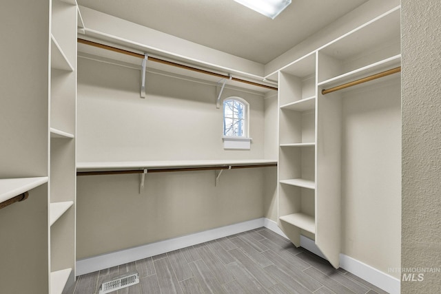 spacious closet featuring wood tiled floor and visible vents