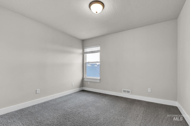 unfurnished room featuring carpet floors, baseboards, visible vents, and a textured ceiling