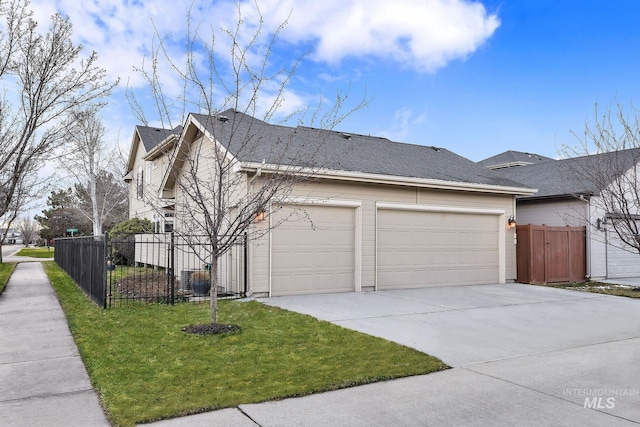 view of side of home with a garage, concrete driveway, a yard, and fence