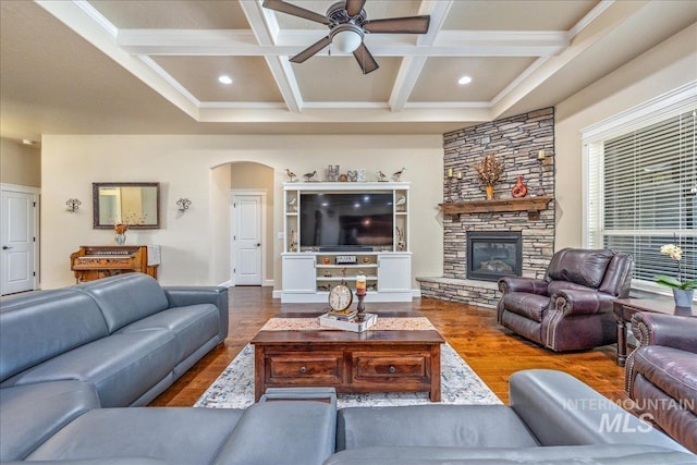 11954 W Meadowfalls Dr, Star, ID 83669 - living area featuring wood finished floors, arched walkways, ceiling fan, beam ceiling, and a stone fireplace