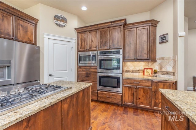 11954 W Meadowfalls Dr, Star, ID 83669 - kitchen with appliances with stainless steel finishes, light stone counters, dark wood-style flooring, backsplash, and recessed lighting
