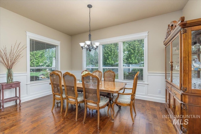 11954 W Meadowfalls Dr, Star, ID 83669 - dining space with a chandelier, a wainscoted wall, dark wood-type flooring, and a decorative wall
