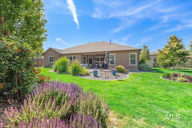 11954 W Meadowfalls Dr, Star, ID 83669 - back of house with a patio area, a yard, and stucco siding