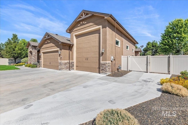 11954 W Meadowfalls Dr, Star, ID 83669 - view of side of property with a gate, stucco siding, and stone siding