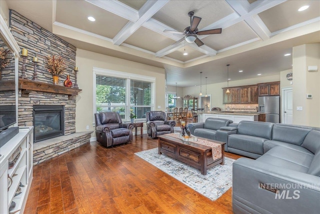 11954 W Meadowfalls Dr, Star, ID 83669 - living room featuring dark wood-style flooring, ceiling fan, coffered ceiling, beamed ceiling, and a stone fireplace
