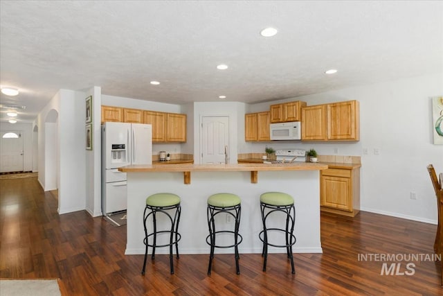 4456 N Weston Ave, Meridian, ID 83646 - kitchen featuring white appliances, arched walkways, light countertops, dark wood finished floors, and recessed lighting