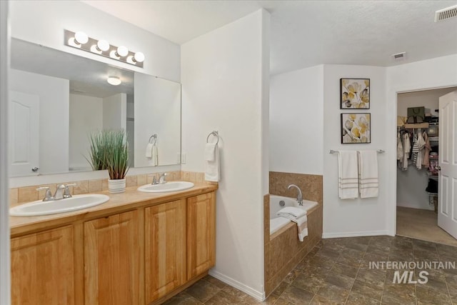 4456 N Weston Ave, Meridian, ID 83646 - full bathroom with double vanity, a bath, a walk in closet, and baseboards