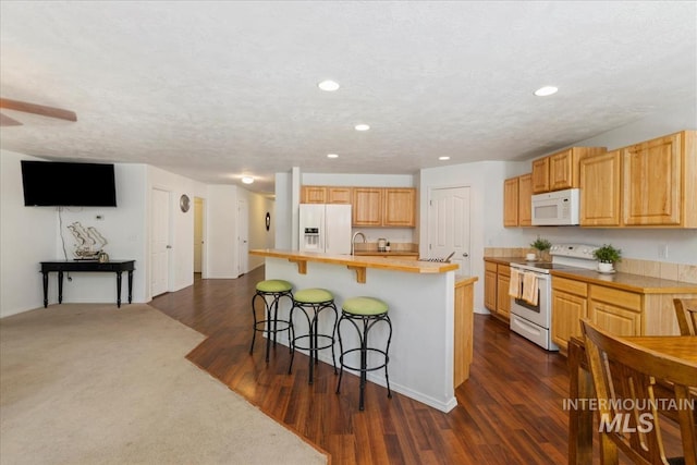 4456 N Weston Ave, Meridian, ID 83646 - kitchen with white appliances, light countertops, a kitchen bar, recessed lighting, and an island with sink