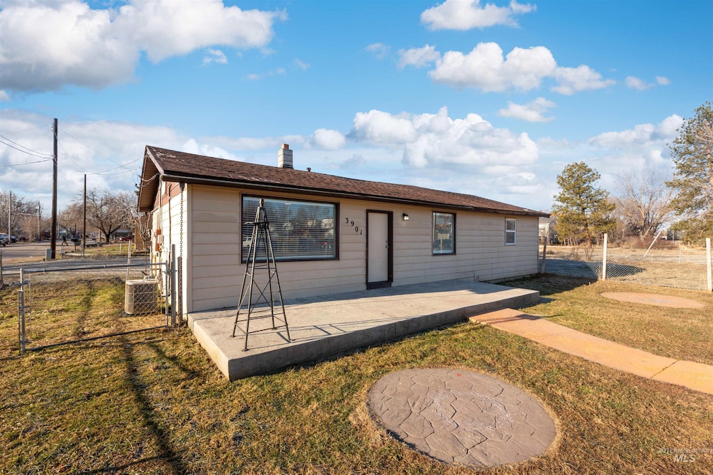 view of front of house with a front yard, central AC unit, and a patio