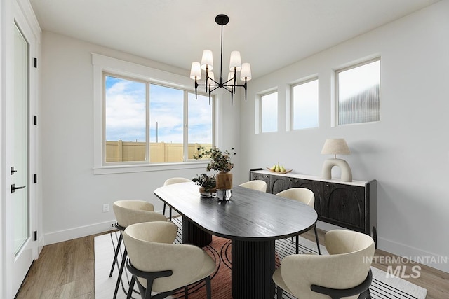 6998 S Tindaris Ave, Meridian, ID 83642 - dining room featuring a chandelier, wood finished floors, and healthy amount of natural light