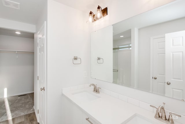 5289 E Grizzly St, Nampa, ID 83687 - bathroom featuring a spacious closet, double vanity, recessed lighting, an enclosed shower, and wood finished floors