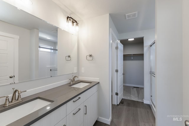5289 E Grizzly St, Nampa, ID 83687 - bathroom with wood finished floors, double vanity, baseboards, and a walk in closet