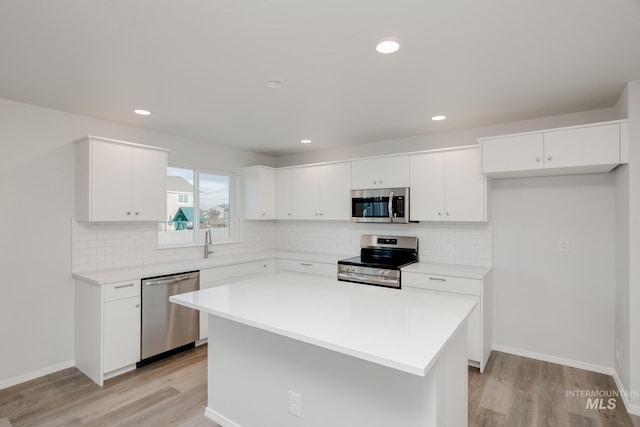 5289 E Grizzly St, Nampa, ID 83687 - kitchen with appliances with stainless steel finishes, light wood-type flooring, backsplash, light countertops, and white cabinetry