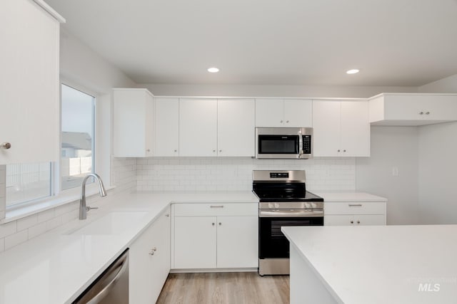 5289 E Grizzly St, Nampa, ID 83687 - kitchen featuring appliances with stainless steel finishes, a sink, white cabinets, light countertops, and recessed lighting