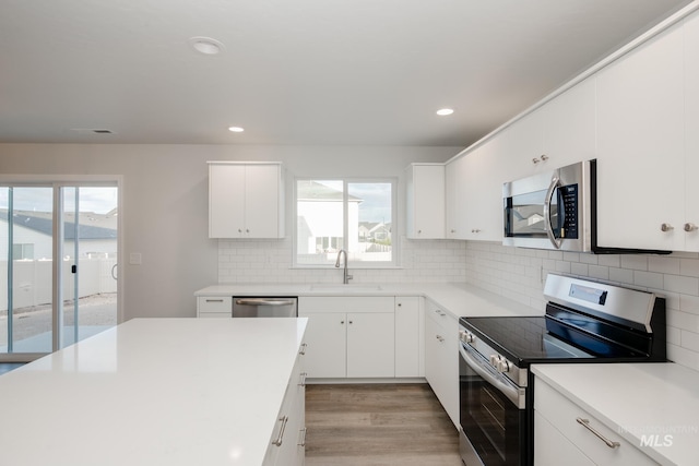 5289 E Grizzly St, Nampa, ID 83687 - kitchen with light wood-style flooring, recessed lighting, a sink, backsplash, and stainless steel appliances