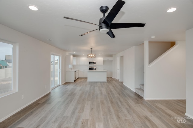 5289 E Grizzly St, Nampa, ID 83687 - unfurnished living room with light wood finished floors, a ceiling fan, stairs, recessed lighting, and baseboards