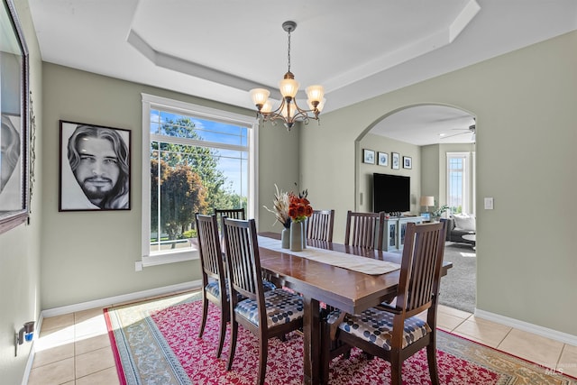 2570 Reservoir Rd, Clarkston, WA 99403 - dining room featuring arched walkways, a chandelier, a raised ceiling, light tile patterned floors, and baseboards