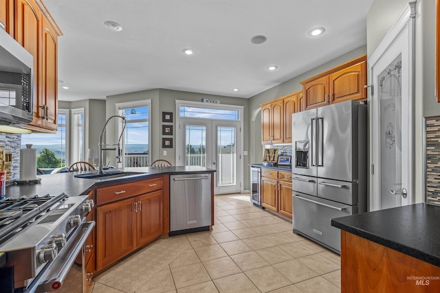 2570 Reservoir Rd, Clarkston, WA 99403 - kitchen featuring appliances with stainless steel finishes, a sink, dark countertops, backsplash, and beverage cooler