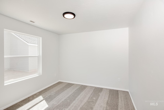 carpeted empty room featuring plenty of natural light