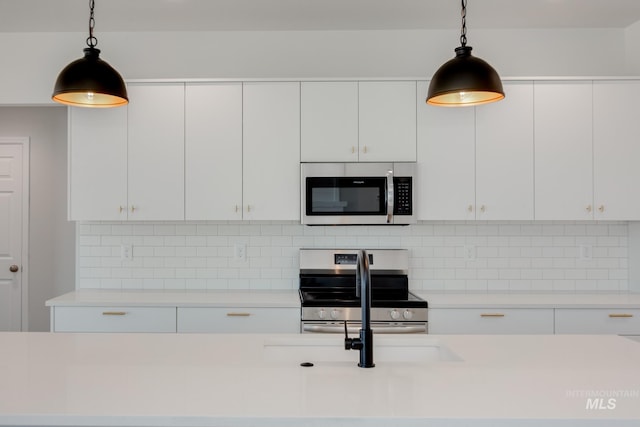 kitchen featuring white cabinetry, appliances with stainless steel finishes, and pendant lighting