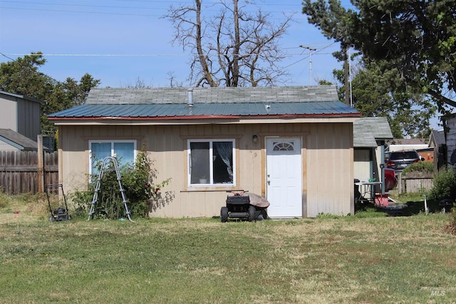 back of house featuring a storage shed and a yard