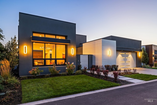 contemporary home featuring a garage and a lawn