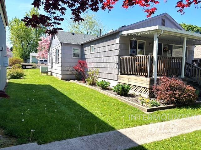 view of side of home with a yard and a porch