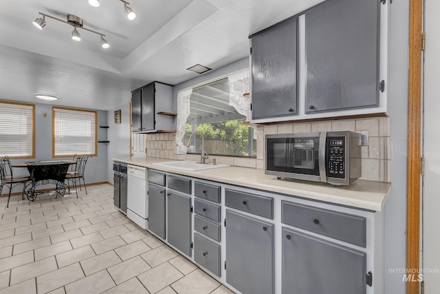 5132 S Council Bluffs Way, Boise, ID 83716 - kitchen with stainless steel microwave, a sink, dishwasher, gray cabinetry, and decorative backsplash