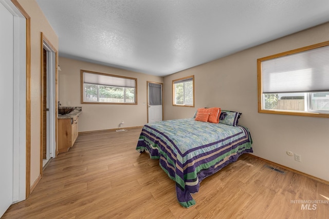 5132 S Council Bluffs Way, Boise, ID 83716 - bedroom featuring light wood-style floors, baseboards, and a textured ceiling