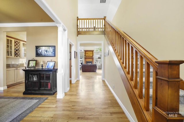 3408 Ridgeline Dr, Kimberly, ID 83341 - foyer entrance featuring stairs, decorative columns, a bar, baseboards, and light wood-style floors