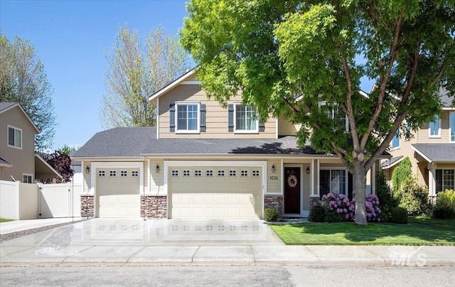 4226 E Tahiti St, Meridian, ID 83646 - view of front of home with concrete driveway, a garage, stone siding, and a gate