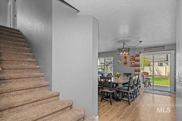 4226 E Tahiti St, Meridian, ID 83646 - stairs featuring a chandelier, wood finished floors, a textured ceiling, and a textured wall