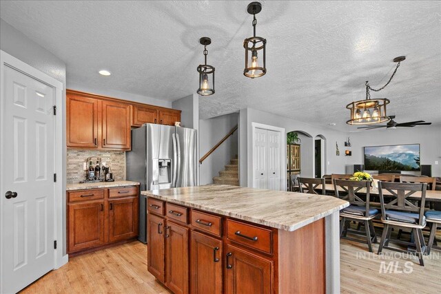 4226 E Tahiti St, Meridian, ID 83646 - kitchen featuring arched walkways, light wood-style floors, decorative light fixtures, a textured ceiling, and recessed lighting