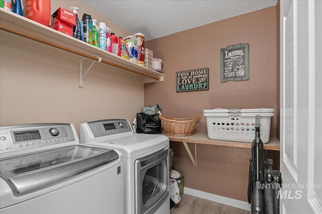 4226 E Tahiti St, Meridian, ID 83646 - washroom featuring washing machine and clothes dryer, wood finished floors, baseboards, and a textured ceiling