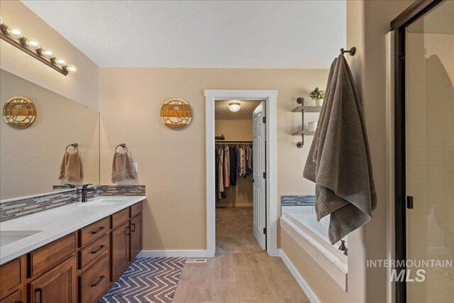 4226 E Tahiti St, Meridian, ID 83646 - full bathroom with double vanity, an enclosed shower, decorative backsplash, baseboards, and wood finished floors
