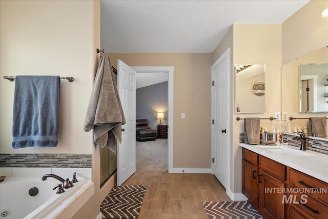 4226 E Tahiti St, Meridian, ID 83646 - full bath with a whirlpool tub, vanity, wood finished floors, a textured ceiling, and a stall shower
