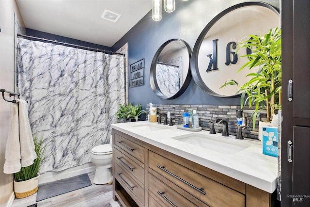 bathroom with a shower with shower curtain, hardwood / wood-style floors, vanity, toilet, and tile walls