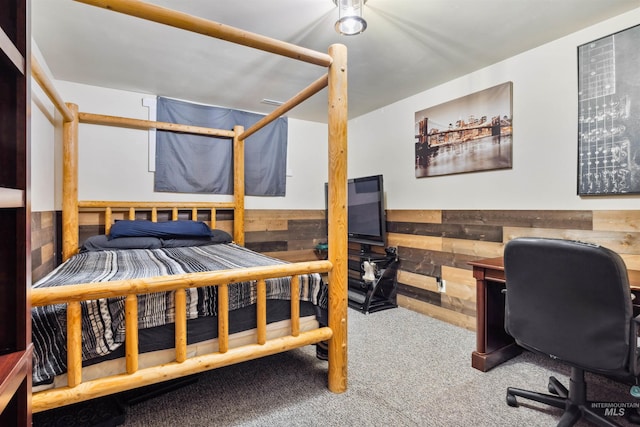 carpeted bedroom with wood walls