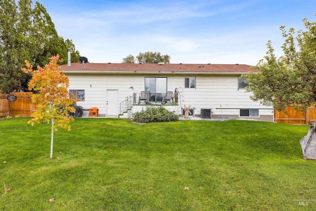 back of house with central air condition unit and a lawn