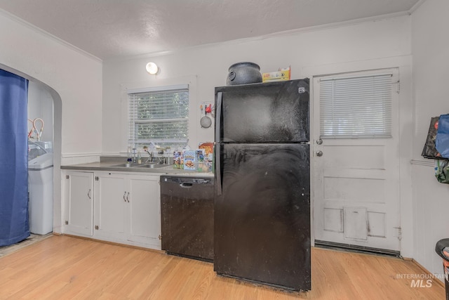538 N 6th St, Payette, ID 83661 - kitchen with black appliances, light wood-style flooring, white cabinets, crown molding, and arched walkways