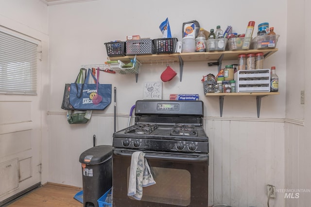 538 N 6th St, Payette, ID 83661 - kitchen featuring black range with gas stovetop, wood finished floors, and wainscoting