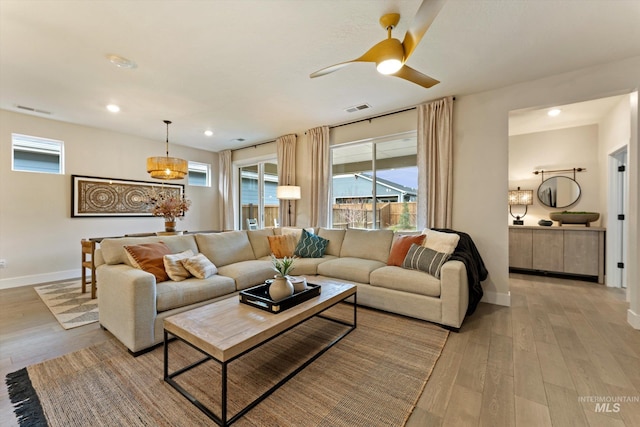 living room with ceiling fan and light hardwood / wood-style floors