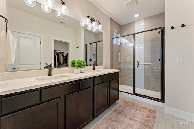 bathroom featuring vanity, hardwood / wood-style flooring, and a shower with shower door