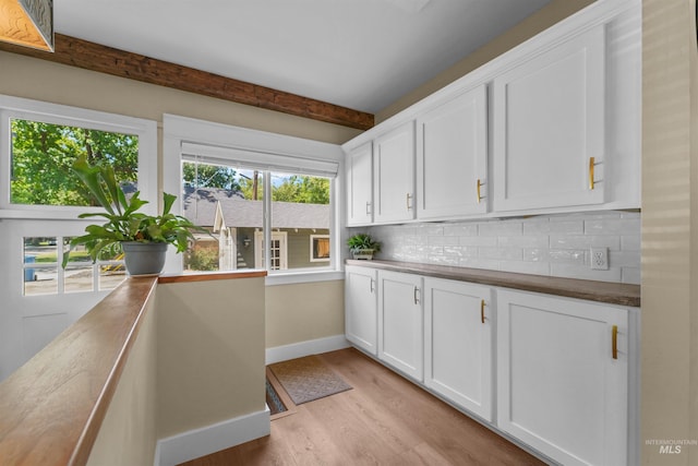 1924 Cleveland Blvd, Caldwell, ID 83605 - kitchen featuring tasteful backsplash, light wood-type flooring, white cabinets, beamed ceiling, and dark countertops