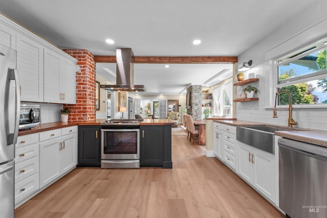 1924 Cleveland Blvd, Caldwell, ID 83605 - kitchen featuring appliances with stainless steel finishes, wall chimney exhaust hood, light wood-type flooring, tasteful backsplash, and beamed ceiling