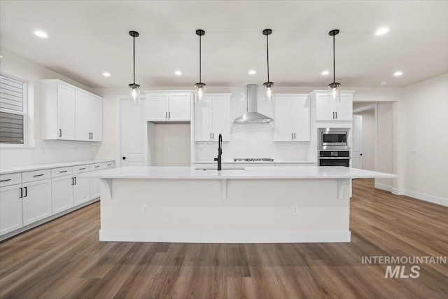 5801 W Escalante, Eagle, ID 83616 - kitchen with wall chimney range hood, white cabinets, appliances with stainless steel finishes, a sink, and wood finished floors