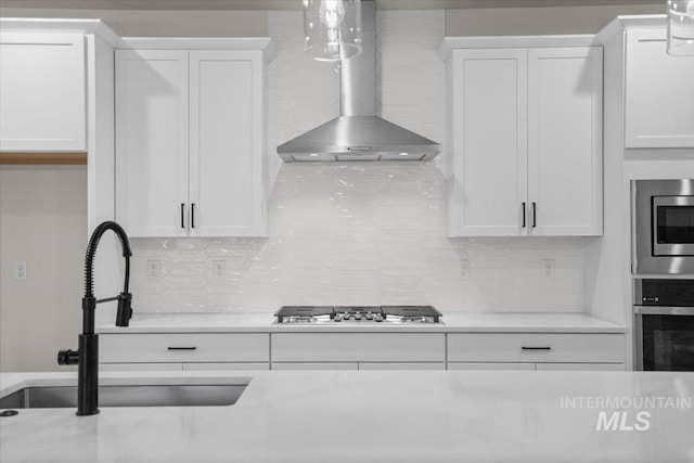 5801 W Escalante, Eagle, ID 83616 - kitchen featuring appliances with stainless steel finishes, a sink, wall chimney range hood, and white cabinets