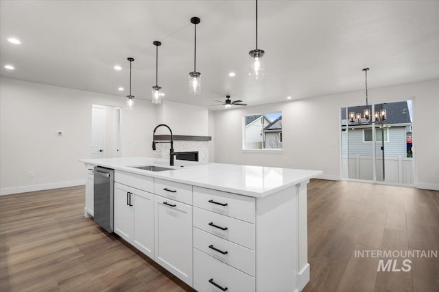 5801 W Escalante, Eagle, ID 83616 - kitchen featuring dishwasher, a sink, light countertops, ceiling fan with notable chandelier, and light wood-style flooring