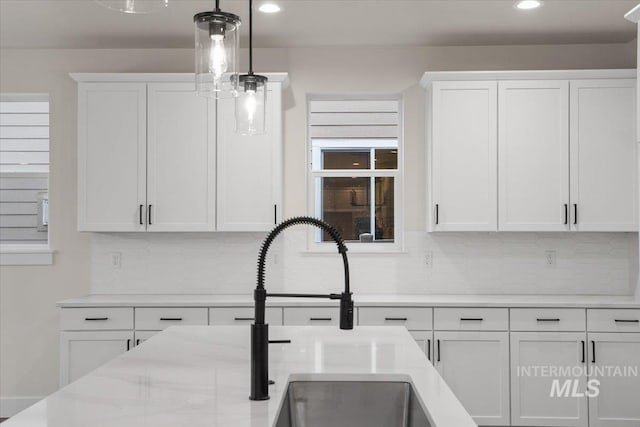 5801 W Escalante, Eagle, ID 83616 - kitchen with recessed lighting, white cabinetry, light stone countertops, decorative backsplash, and hanging light fixtures