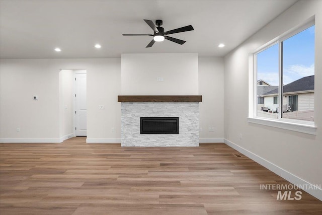5801 W Escalante, Eagle, ID 83616 - unfurnished living room featuring a fireplace, light wood-type flooring, a ceiling fan, recessed lighting, and baseboards